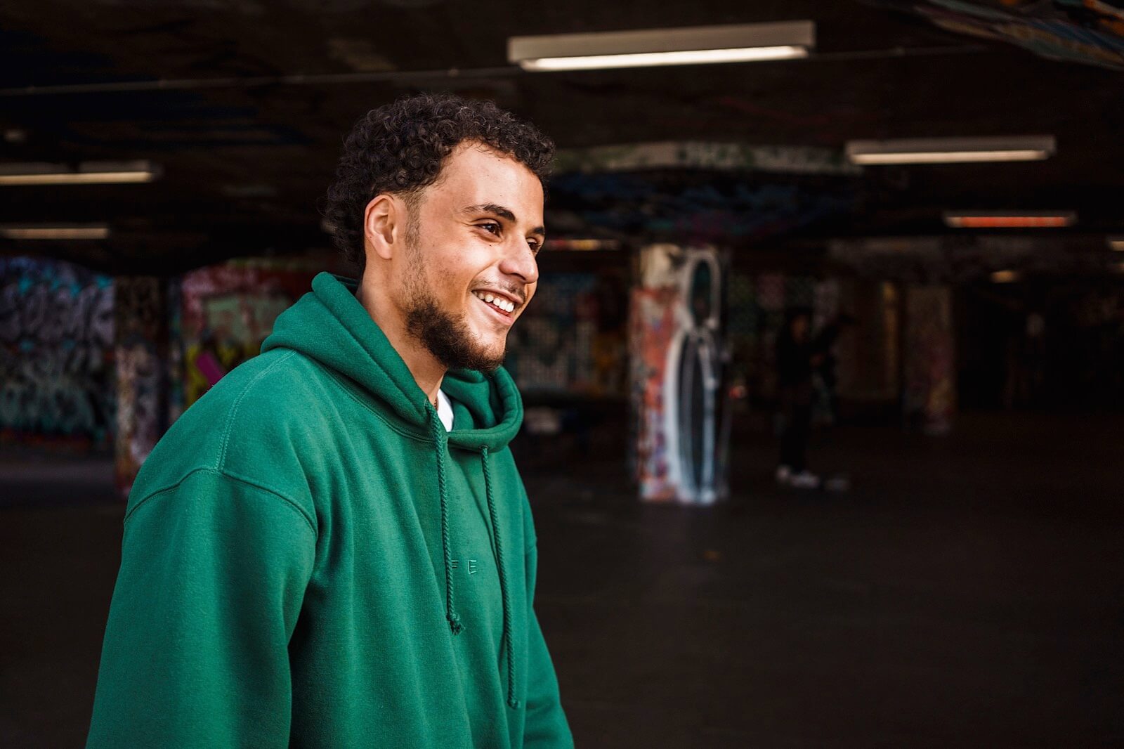 Portrait of young man wearing a green jumper at Waterloo Skate Park